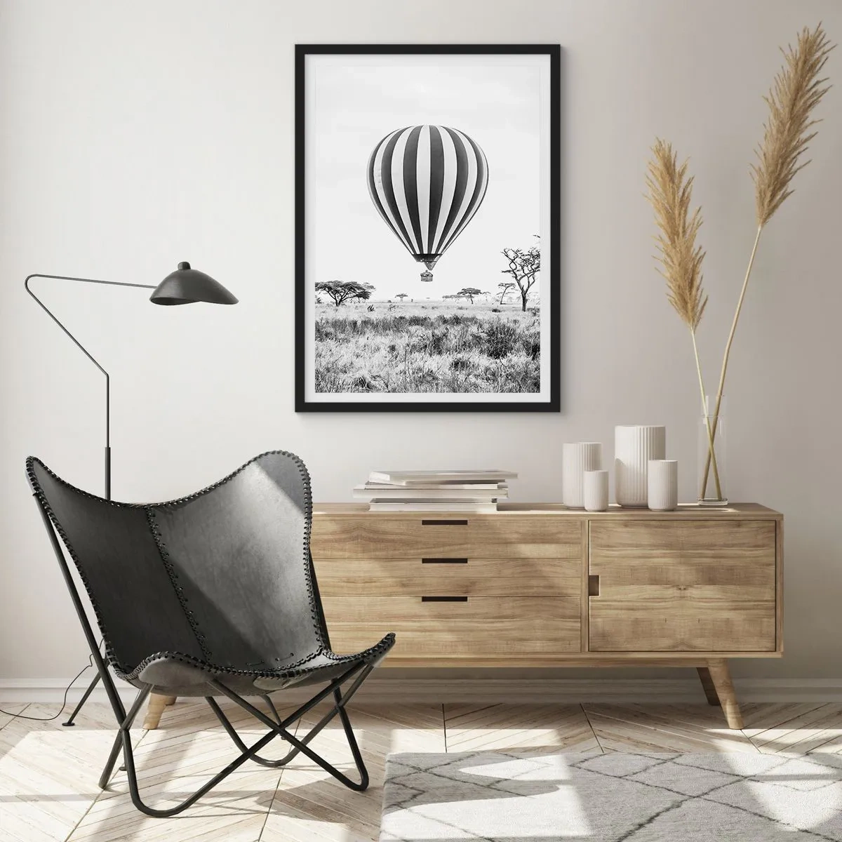 Plakát v černém rámu - Horkovzdušný balón vznášející se nad savanou v černé a bílé. - 50x70cm - Nad savanou - Moderní nástěnná dekorace do obývacího pokoje a ložnice ARTTOR