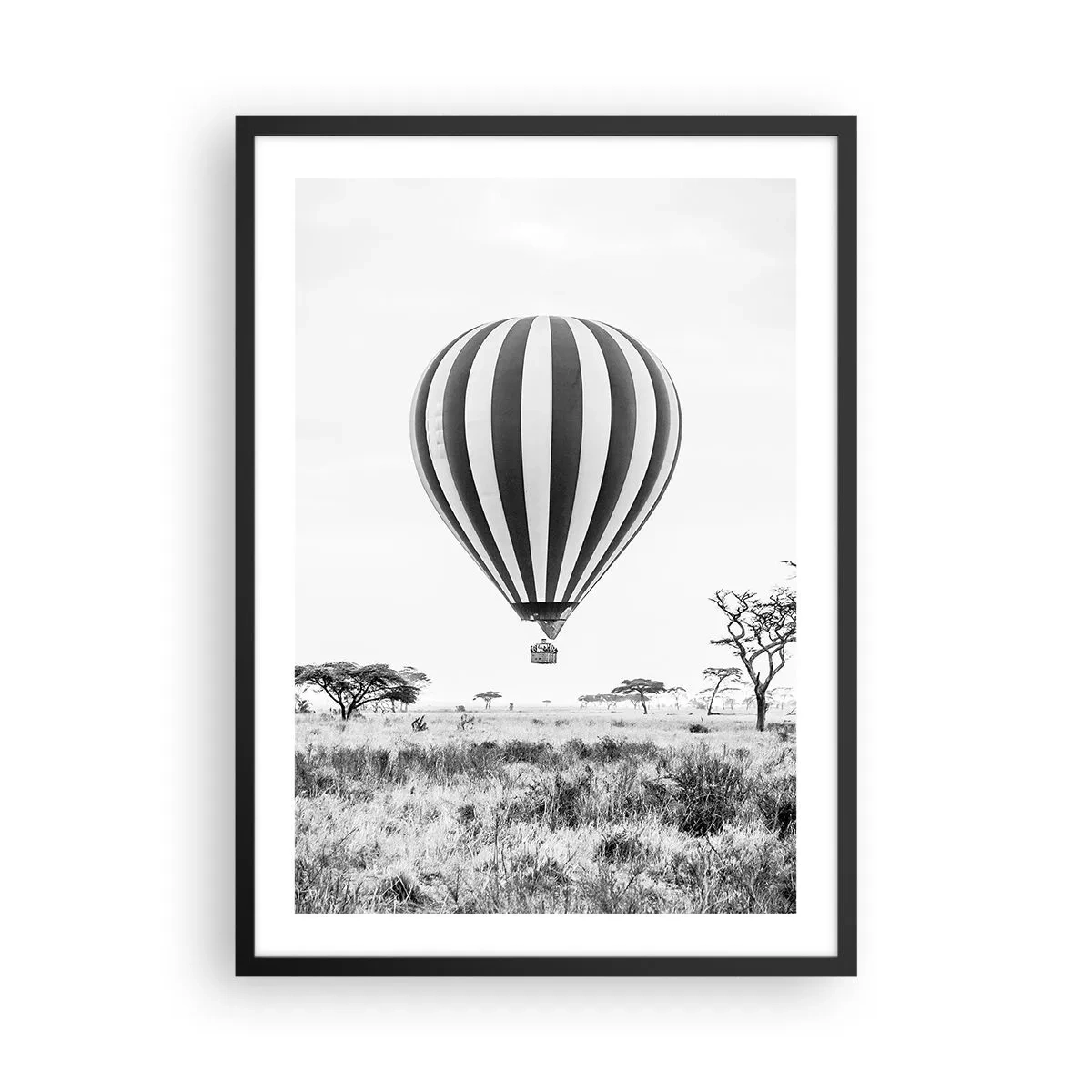 Plakát v černém rámu - Horkovzdušný balón vznášející se nad savanou v černé a bílé. - 50x70cm - Nad savanou - Moderní nástěnná dekorace do obývacího pokoje a ložnice ARTTOR