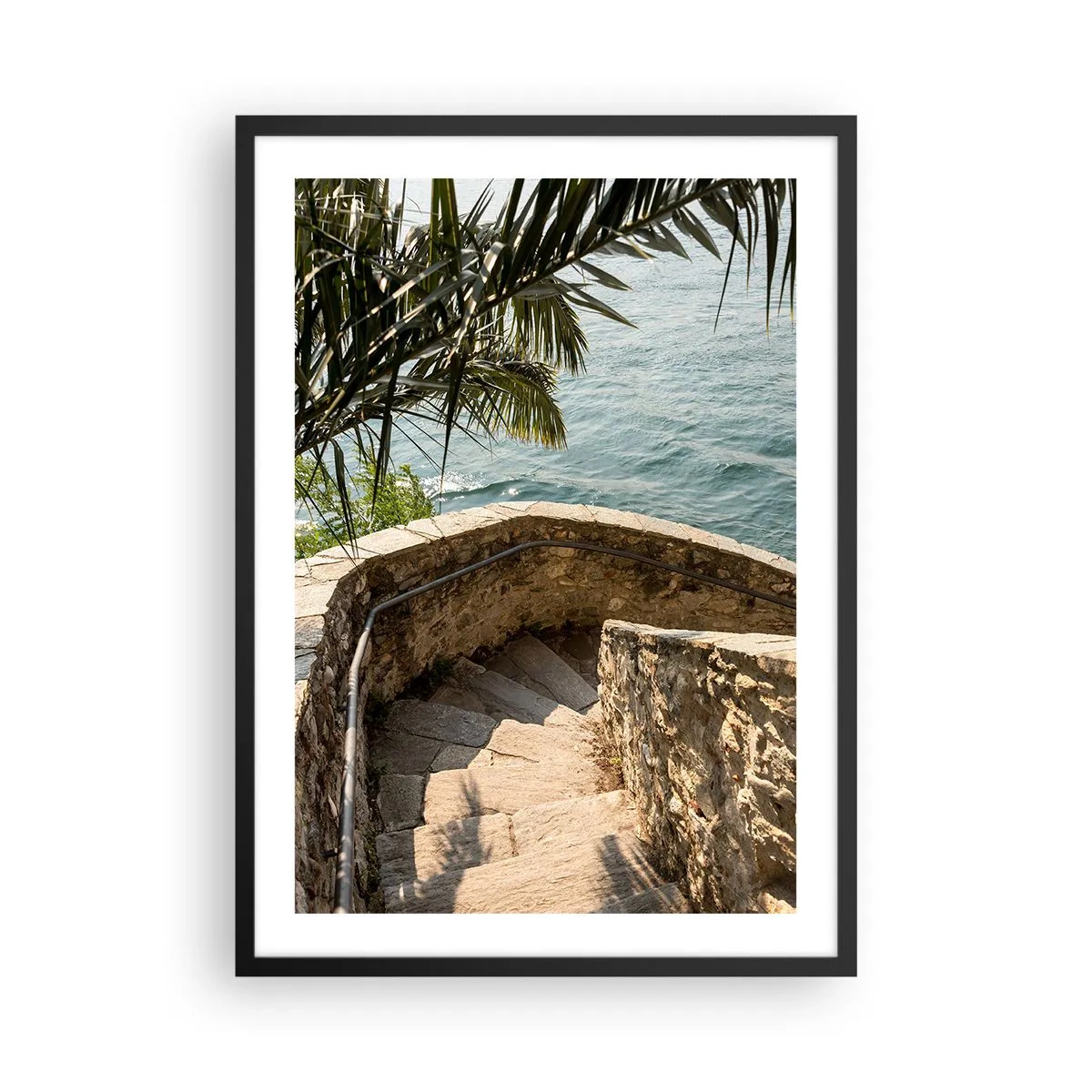 Plakát v černém rámu - Kamenné točité schodiště vedoucí k moři, lemované palmami - 50x70cm - Pod italským sluncem - Moderní nástěnná dekorace do obývacího pokoje a ložnice ARTTOR